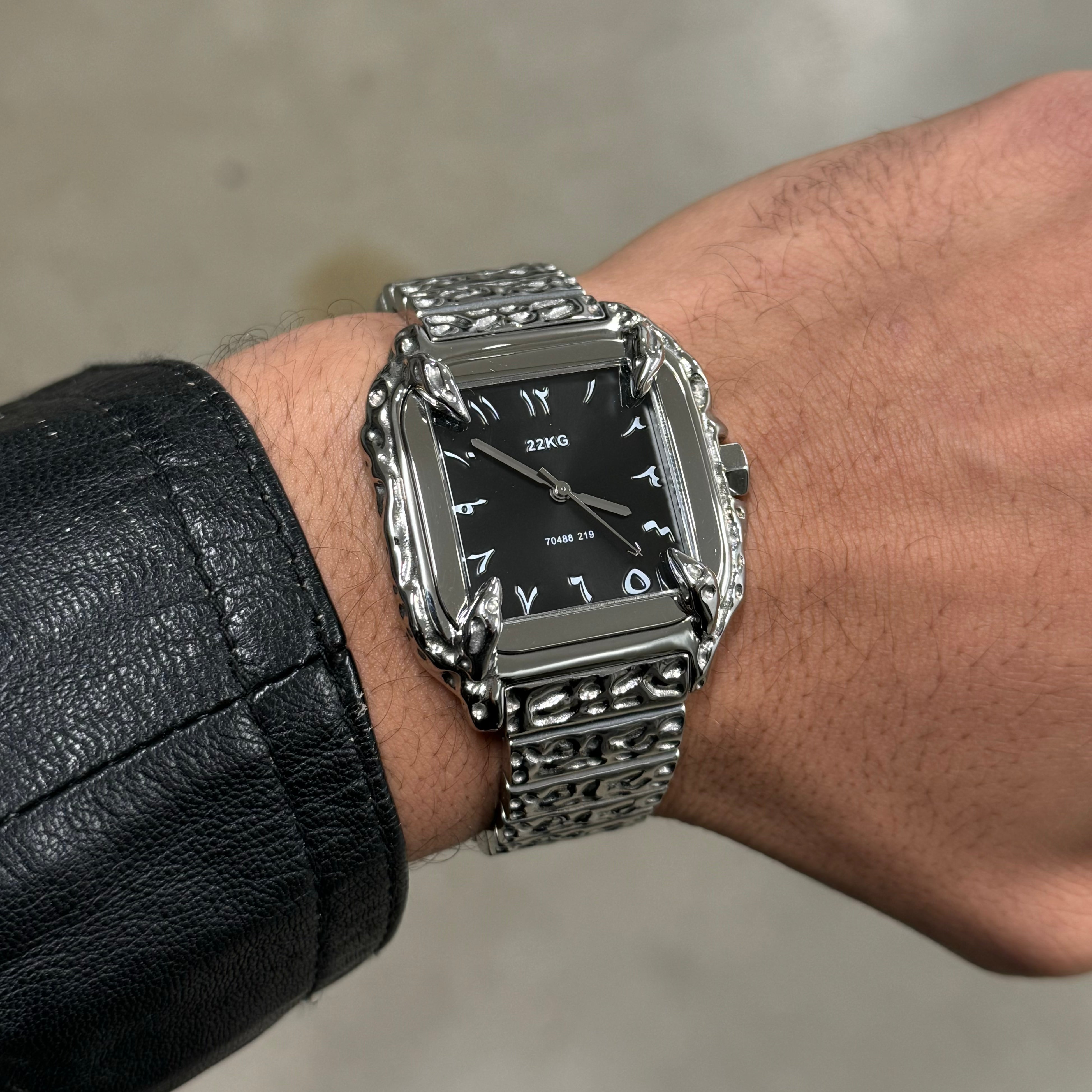 Silver 22KG CANINE watch with black face on a wrist against a neutral background